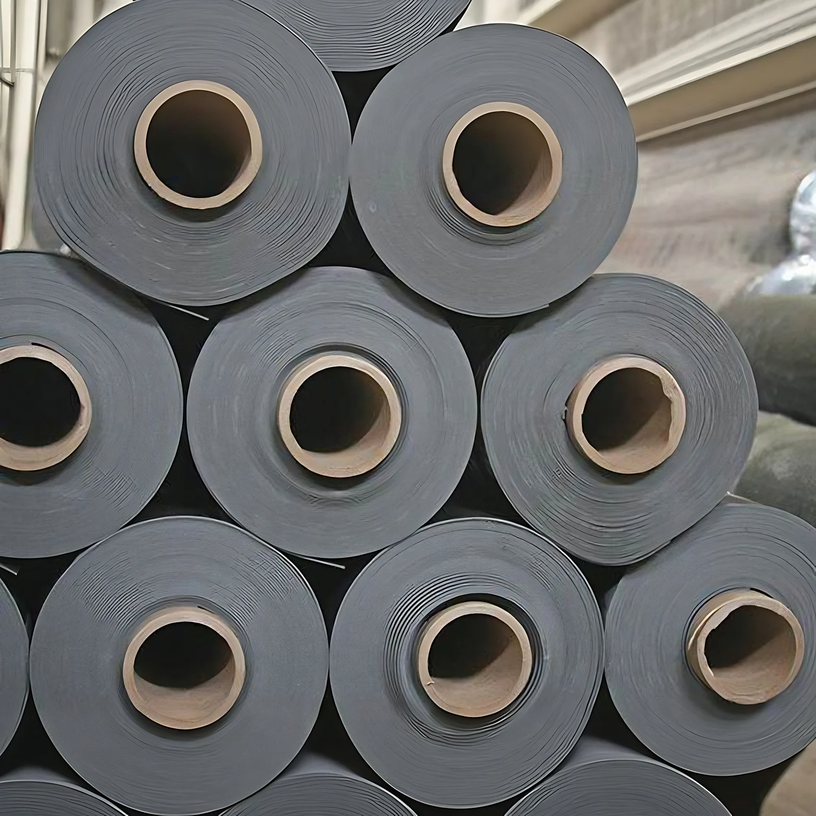Stacked rolls of 0.6 lb per square foot Wall Blokker Lite sound blocking membrane seen end on