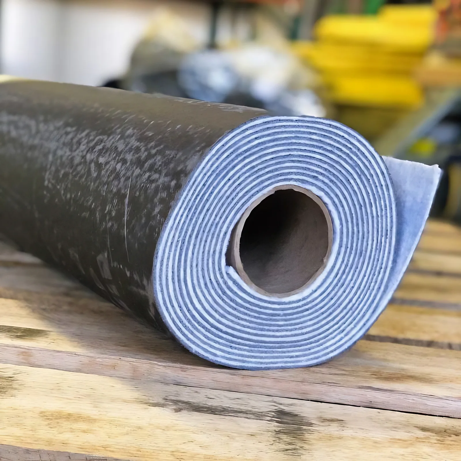 Roll of Wall Blokker Pro mass loaded vinyl with the scrim face showing at the roll end