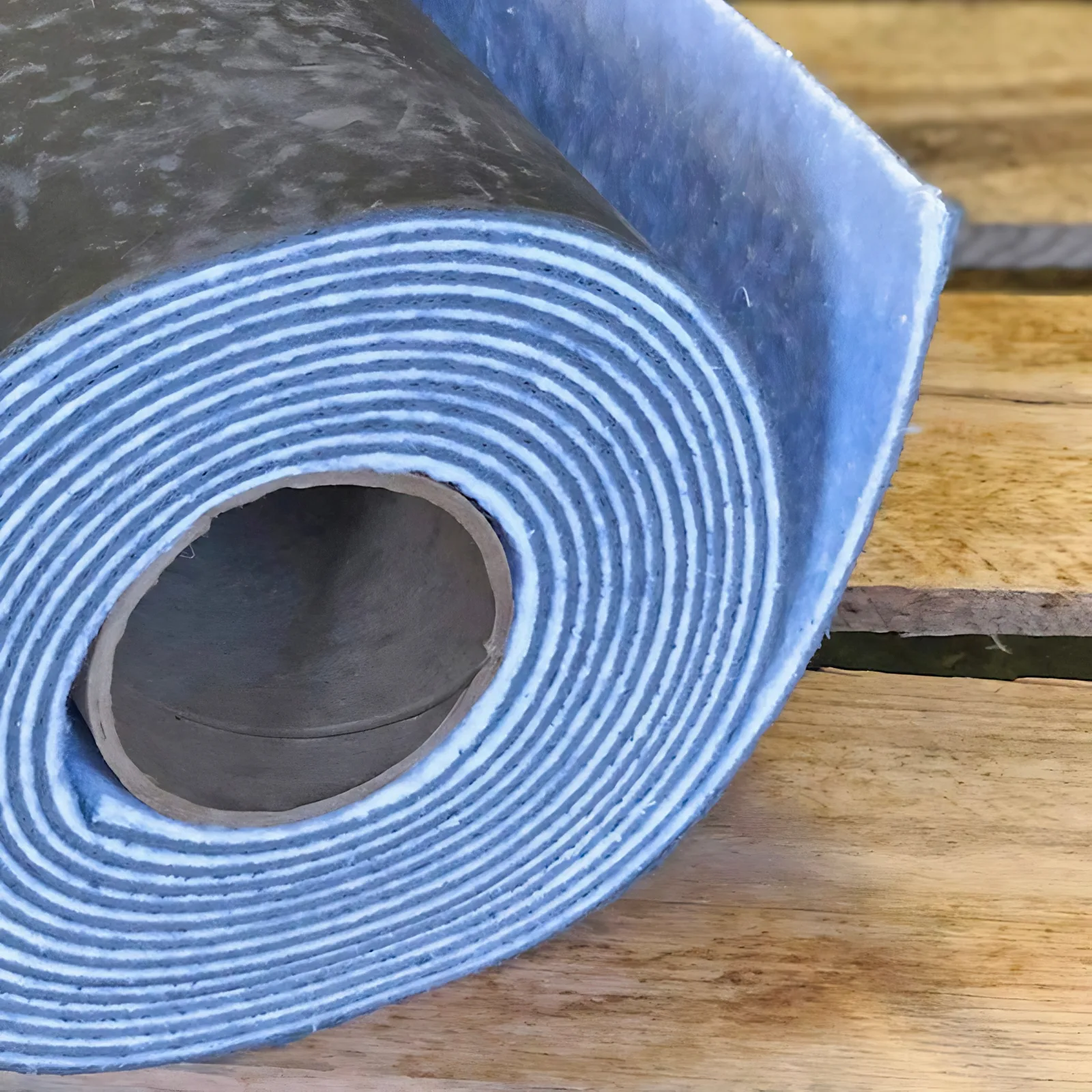 Close-up of a Wall Blokker Pro roll showing the polyethylene scrim fused to the mass loaded vinyl